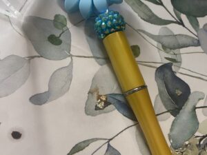 Blue Sunflower Pen. Writes in black ink.